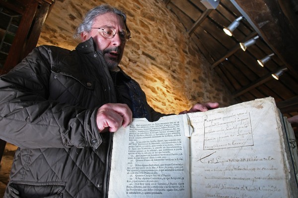 El alcalde pedáneo de Santa Marina de Torre (León), Melchor Moreno, junto a los libros sobre las leyes de España y de la Corona de Castilla de los siglos XVIII y principios del XIX. (Foto: César Sánchez)