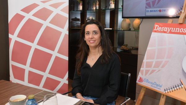Mujer sentada en una mesa con un banner de El Bierzo Digital detrás.